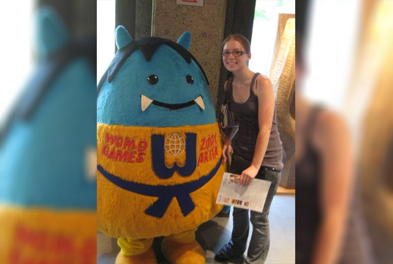 Kristen Dexter standing next to a cute blue ogre mascot